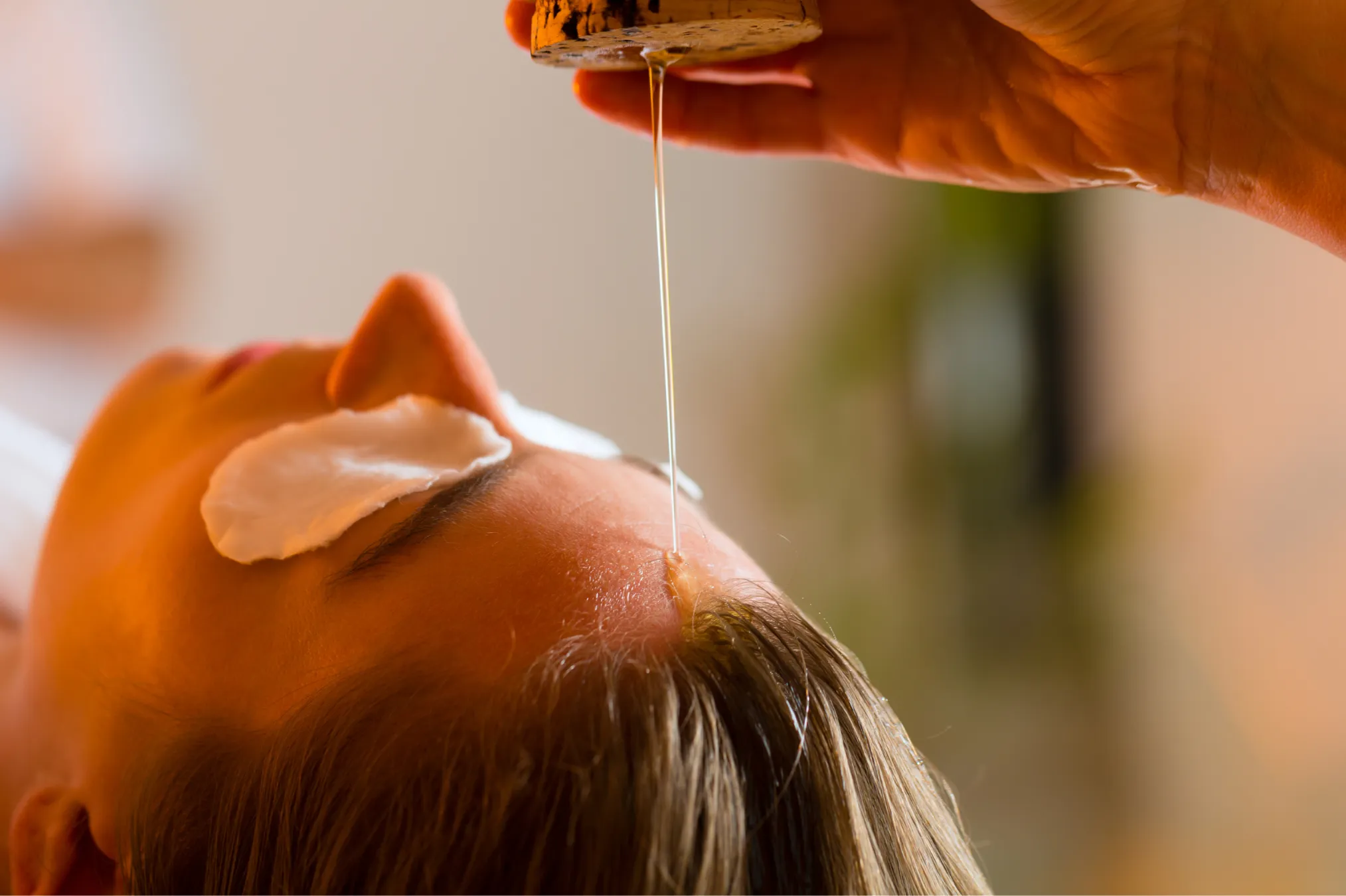 Ayurvedic Shirodhara therapy for stress relief with warm herbal oil poured on the forehead